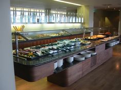 a buffet with many different types of food on the counter and plates in front of it