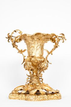 an ornate gold vase sitting on top of a table