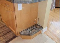 a kitchen sink sitting in the middle of a wooden floor