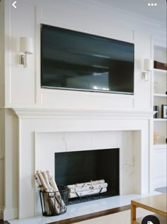 a living room with a large flat screen tv mounted on the wall above a fireplace