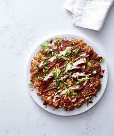 a white plate topped with a pizza covered in toppings