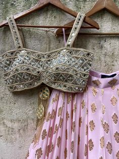 A three-piece powder pink butti mirror lehenga set from the Priti Sahni collection. This elegant powder pink butti georgette lehenga with big ruffle detailing and gota border is paired with our classic pearl work and mirror bustier. The lehenga has side hanging ball tassels to the waistline. And the blouse has a mirror-sequins tassel tie-up at the back. The outfit is completed with a powder pink net sequined butti work dupatta with scalloped edging. Pink Gota Work Choli For Reception, Pink Sequined Georgette Sets, Pink Mirror Work Sharara For Reception, Pink Sharara With Mirror Work For Reception, Pink Mirror Work Sets For Navratri, Pink Sets With Mirror Work For Navratri, Pink Party Sharara With Cutdana, Pink Sequined Georgette Lehenga, Pink Sequined Anarkali Set For Navratri