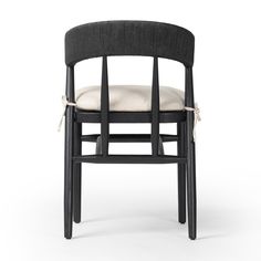 a black chair with a white seat and back cushion on top of it, in front of a white background