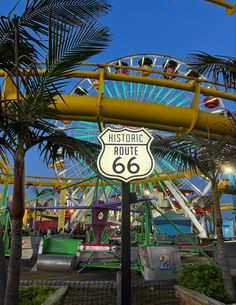 a sign that reads historic route 66 in front of a roller coaster at an amusement park