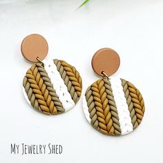 a pair of earrings with two different colors and designs on the bottom one is brown, white, and tan