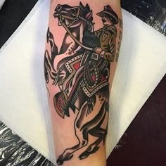 a man with a horse tattoo on his arm and leg is holding an arrow in one hand