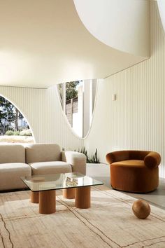 a living room filled with furniture next to a large round window on top of a wall