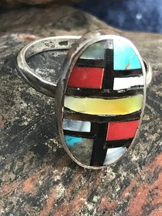 Vintage sterling Zuni ring with stone to stone inlay of coral, turquoise, shell, and onyx. There are slight gaps in places in the inlay. The ring is interesting, and I believe old. The artisan has chosen to include more gray matrix than turquoise in one panel. This is a soulful and colorful little artisan made ring. The ring is size 6-1/4. The face of the ring is .75 inches long and .47 inches wide. It weighs 3 grams. Ring With Stone, Coral Ring, Navajo Turquoise, Stone Inlay, Coral Turquoise, Fine Rings, Red Coral, Black Beads, Sterling Ring