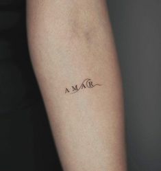 a woman's arm with the word maa tattooed on her left side forearm