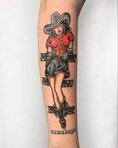 a woman with a cowboy hat and boots on her leg is shown in this tattoo