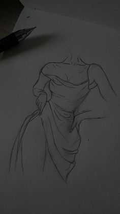 a pencil drawing of a woman's dress on paper with a pen in the foreground