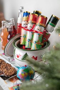 a table topped with plates and cups filled with food next to a christmas ornament