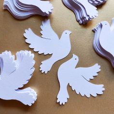 paper cut doves sitting on top of a table