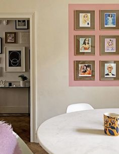 a white table and chairs in a room with pictures on the wall