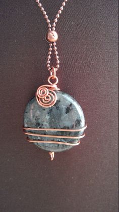 a necklace with a wire wrapped around it and a stone on the back of it