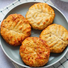 four biscuits on a plate with a cup of coffee in the backgroung