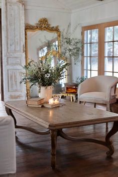 a living room filled with furniture and a large mirror on the wall above it's windows