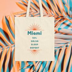 Stylish 100% cotton canvas tote bag comes in one size - 15" x 16" - perfect for everyday use. This iconic Miami inspired design reflects the city's vibrant culture and the canvas material is durable and will last for years. The bag features 20" handles (made from the same canvas), making it easy to use for shopping and running errands.  .: 100% cotton canvas in natural color .: Heavy fabric (12 oz/yd & 406.9 g/m) .: Sewn-in label Palm Springs Tote Bag, Eco-friendly Pink Tote Beach Bag, Eco-friendly Cotton Canvas Bag With Graphic Print, Pink Tropical Tote Bag, Boho Tote Bag, Boho Tote, Feminist Tote Bag, Beach Tote, Beach Tote Bags