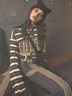 a woman sitting on the floor in a locker Winter Grunge Cotton Tops, Winter Cotton Grunge Tops, Trendy Winter Patchwork Tops, Trendy Patchwork Tops For Winter, Striped Tops For Layering In Fall, Patchwork Stretch Tops For Fall, Grunge Green Tops For Fall, Grunge Relaxed Fit Tops For Fall, Grunge Long Sleeve Tops For Fall