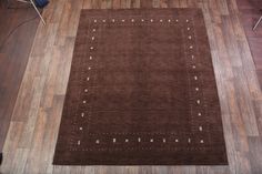 a brown area rug on the floor in a room with wooden floors and hard wood floors