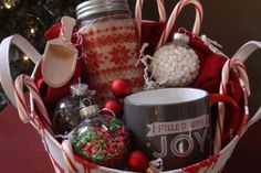 a christmas gift basket with candy canes, hot chocolate and marshmallows