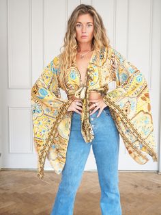 SILK BELL SLEEVE CROP TOP - SUMMER FIELDS  ** LIMITED PRINTS AVAILABLE **  Handmade recycled silk crop kimono with amazing billowing bell sleeves and gold printed fabric!  The gold thread print shimmers and shines, the photos don't do it justice. This incredible silk crop top is the perfect addition to any outfit, with flowing sleeves and bohemian vibe, this is an amazing bespoke piece to add to any wardrobe!  Our 'Bella' tops were dreamed up in the sunshine and are a twist on our classic 'Stevi Stretch V-neck Top For Festival, Yellow Long Sleeve Printed Top, Stretch Long Sleeve Tops For Vacation, Printed Flowy V-neck Tops, Printed Long Sleeve Tops For Beach, Bohemian Stretch Tops For Vacation, Flowy Long Sleeve Beach Top, Bohemian Wrap Flowy Tops, Bohemian Wrap Top For Beach