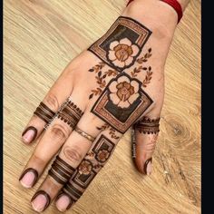 a woman's hand with henna tattoos on it