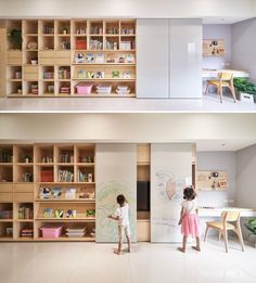 two children are playing in the playroom with bookshelves and desks, while another child is drawing on the wall