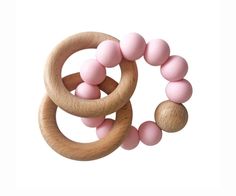 two wooden rings with pink balls on them