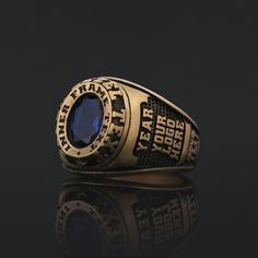 a gold ring with an oval blue stone on the center and words that read fearless