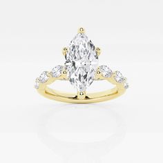 a yellow gold engagement ring with an oval cut diamond in the center and side stones