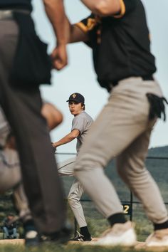 a baseball player getting ready to swing at the ball while others watch from behind him