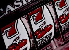 a row of slot machines with red cherries on the front and white letters that read casino jackpots