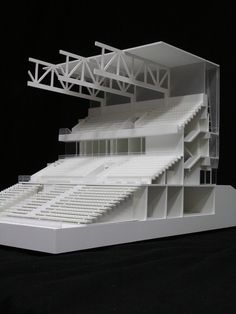 an architectural model of a stadium with white seats and railings on the sides, against a black background