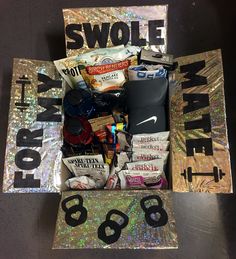 a box filled with assorted items sitting on top of a table next to a sign that says swole