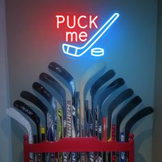 a rack filled with lots of different types of golf clubs in front of a neon sign that reads puck me