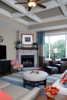 a living room filled with furniture and a flat screen tv mounted on a wall above a fire place