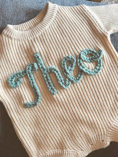 a knitted sweater with the word mom written on it