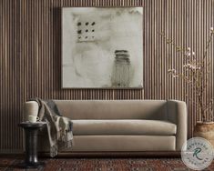 a living room scene with focus on the couch and wall papered in vertical stripes