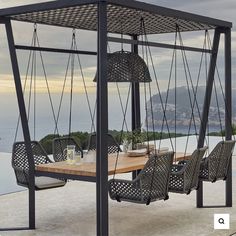 an outdoor dining area with swings and chairs