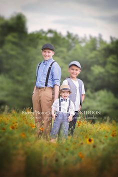 two boys and an older man are standing in a field