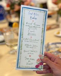 a person holding up a menu at a table