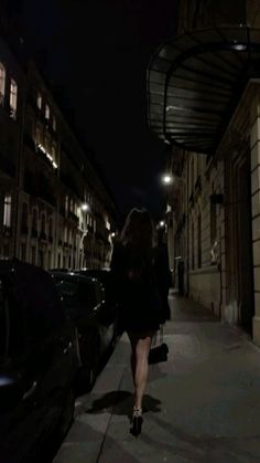 a woman walking down the street at night