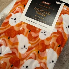 an orange and white polar bear print blanket on top of a pile of fluffy fur