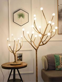 a living room filled with furniture and a light tree next to a table in front of a couch