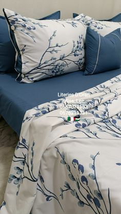 a bed with blue and white sheets and pillows