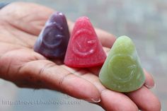 three different colored candies sitting in the palm of someone's hand