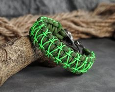 a green paracorine bracelet with metal clasps on a piece of driftwood