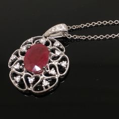 14K Ruby and Diamond Pendant METAL: 14K White Gold TOTAL WEIGHT: 1.7 g DIAMONDS: Round Brilliant Cut Diamonds COLOR: G/H CLARITY: VS2-SI1 TOTAL WEIGHT: 0.16 ct RUBY: Genuine Oval Cut Ruby MEASUREMENTS: 8mm x 6mm TOTAL WEIGHT: 1.40 ct Chain Length: 16, 18, or 20 inch chain is included with your purchase. Please indicate your desired length at checkout. DESCRIPTION: Beautiful Ruby and diamond pendant. This item has a lot of vintage flair. It looks gorgeous on. It's a little under an inch in length Oval Fine Jewelry Necklace With Intricate Design, Exquisite Oval Necklace With Intricate Design, Luxury Oval Necklace With Intricate Design, Oval White Gold Necklace With Intricate Design, Oval Diamond Necklace With Intricate Design, Formal Ruby Necklaces With Intricate Design, Formal Ruby Necklace With Intricate Design, Elegant Red Engraved Jewelry, Elegant Engraved Red Jewelry