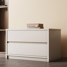 a white dresser with books on top in a room